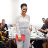 Face of handsome african american business woman, holding tablet Face of handsome african american business woman, holding tablet on the background of business peoples multiracial team meeting, sitting in office table.